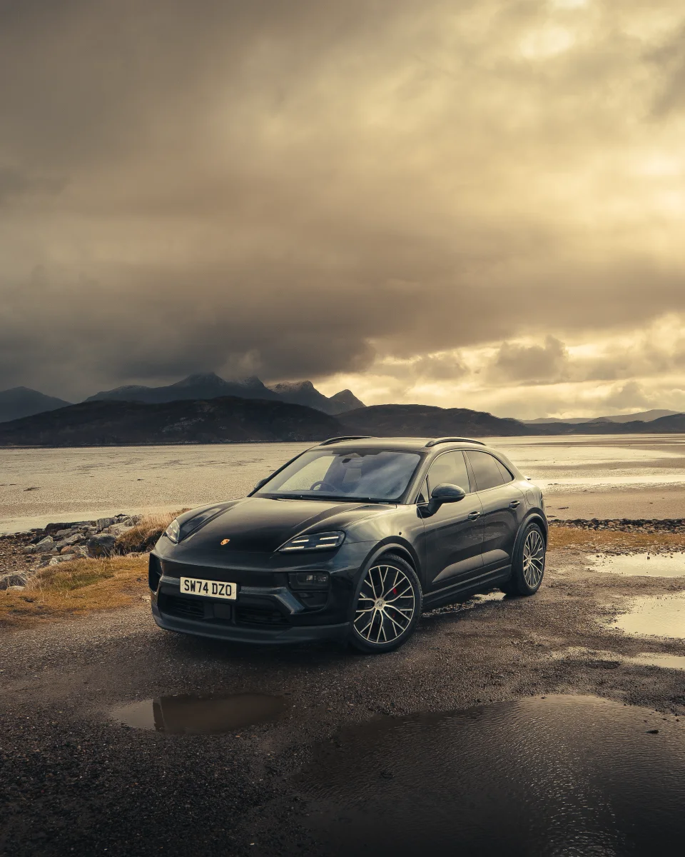 Porsche beside a loch with mountains and golden evening light