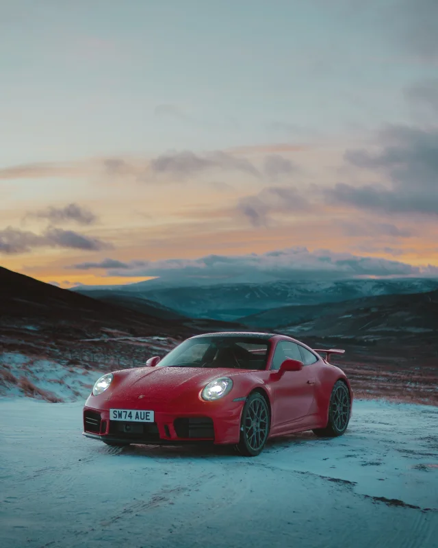 Red Porsche in a snowy mountain landscape