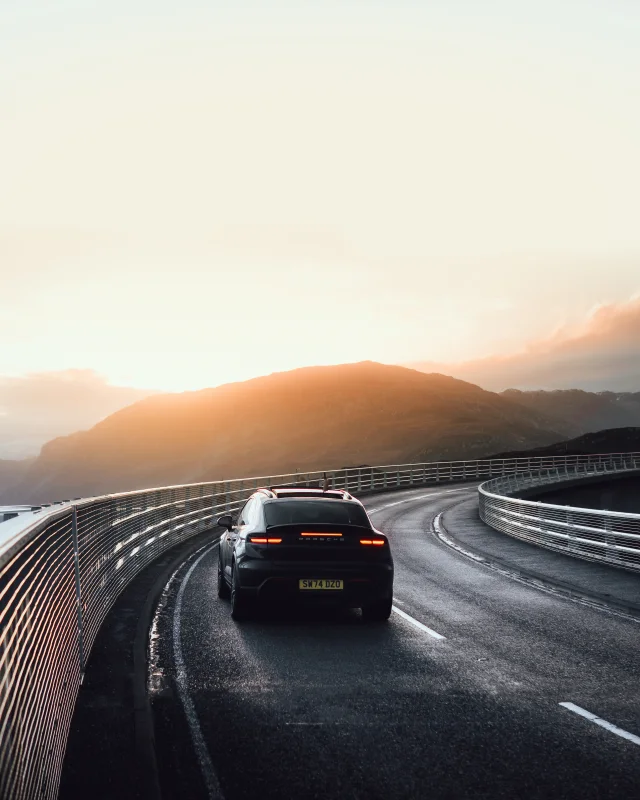 Porsche on a curved road in evening light