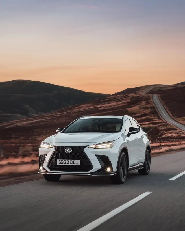 White Lexus driving through the Cairngorms at sunset